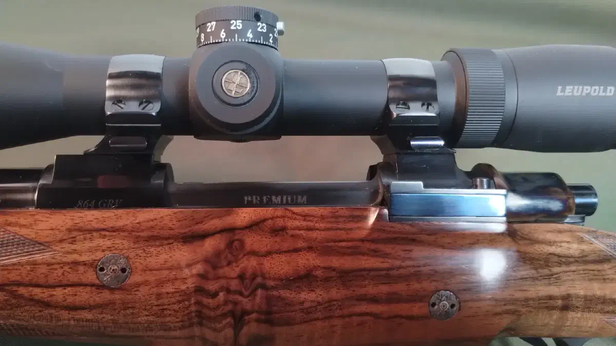 Turkish-walnut stock and blued bolt action of a Premium 9.3×62 rifle, with engraved grip-cap rosettes.